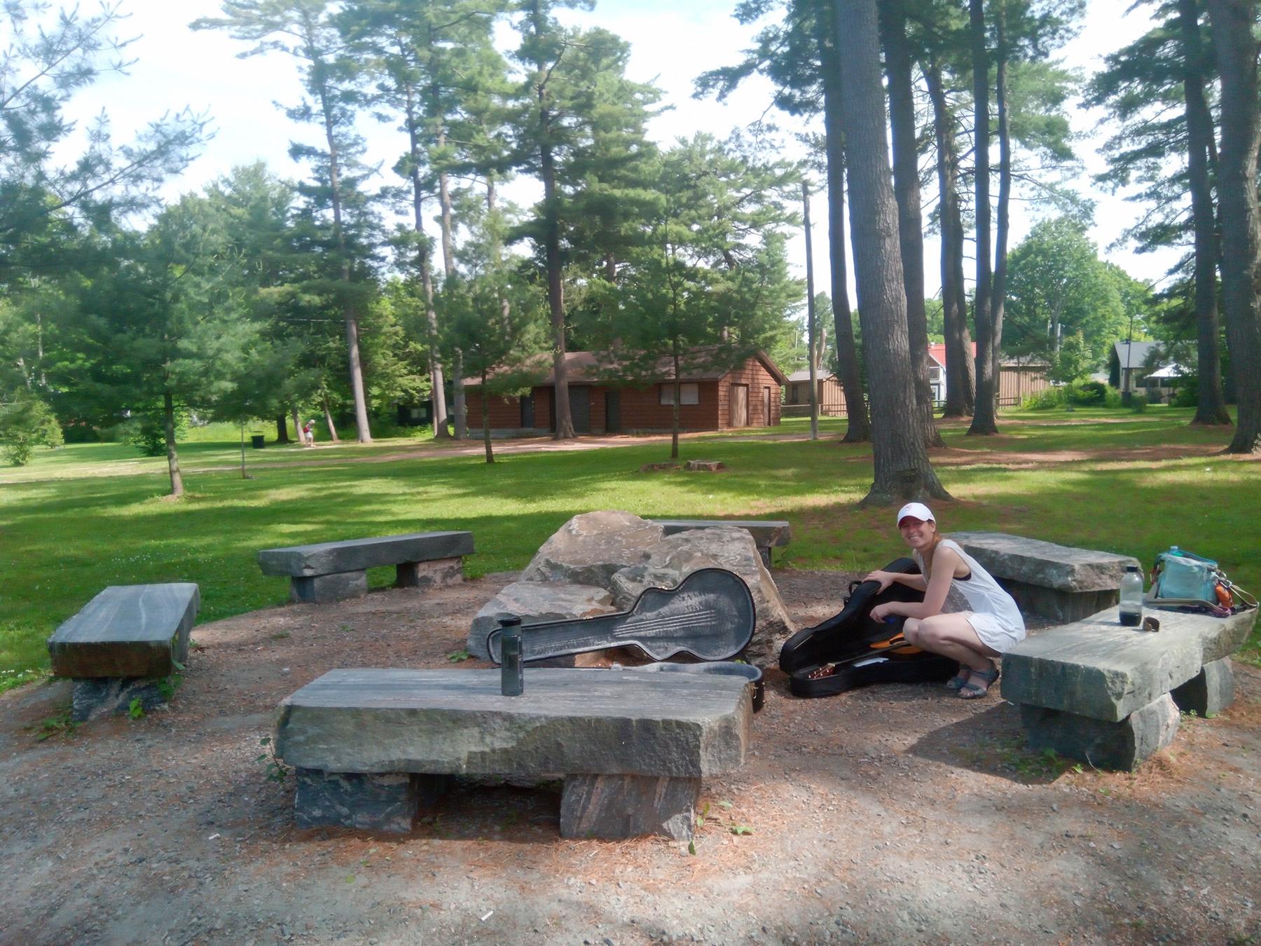 Jenn setting up to jam beside stone benches