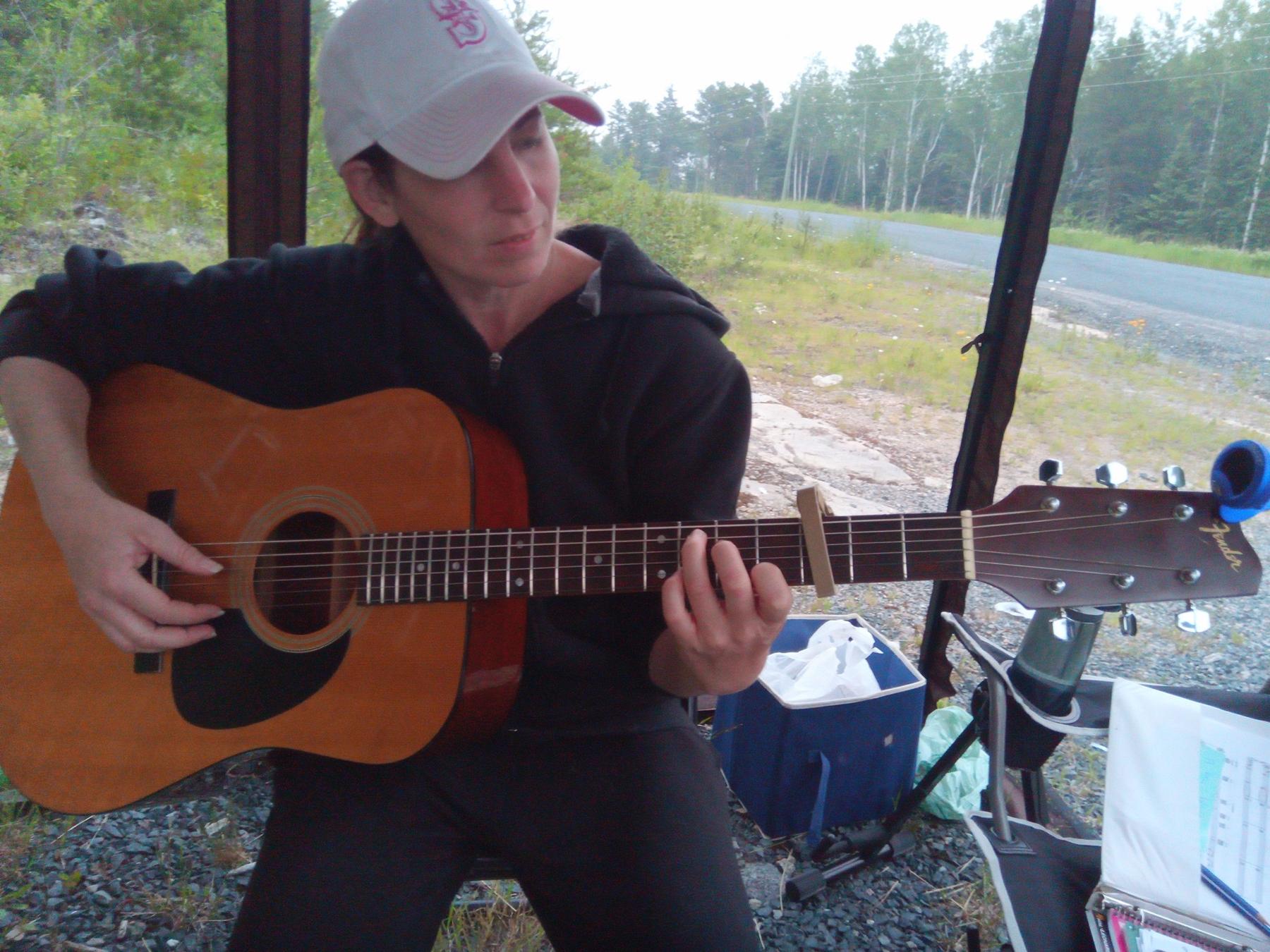 Closeup of Jenn plying guitar