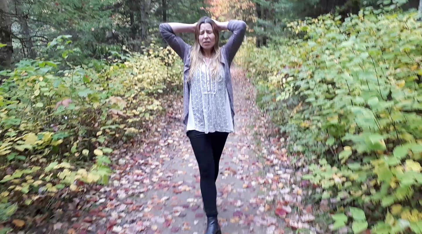 Jenn walking through a forest path