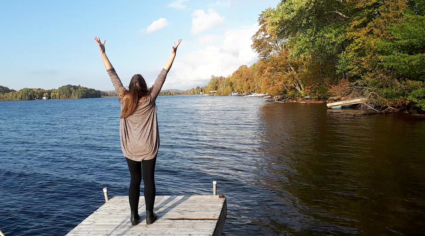 Jenn arms up on a dock
