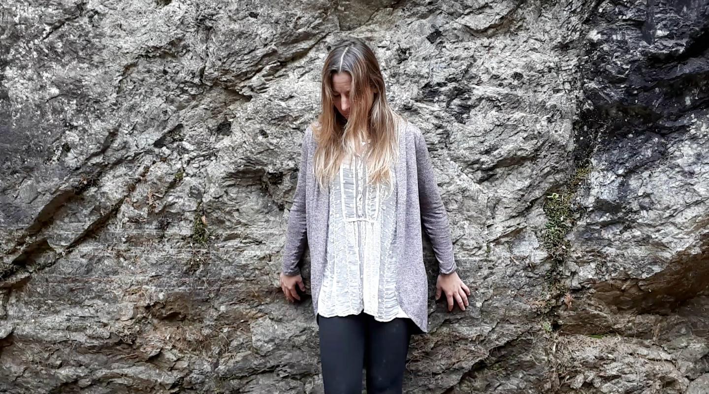 Jenn looking down at the bottom of a small cliff