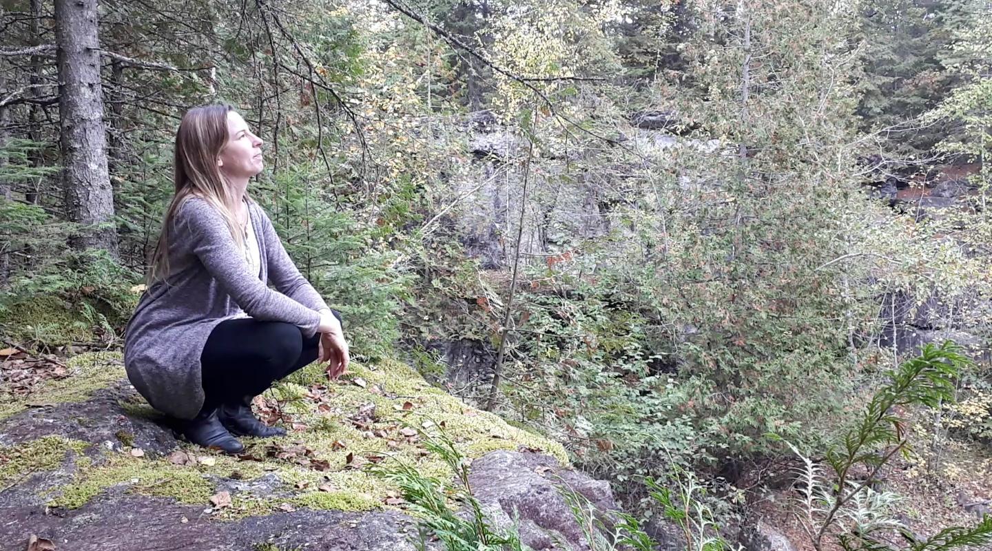 Jenn sitting at the top of a small cliff