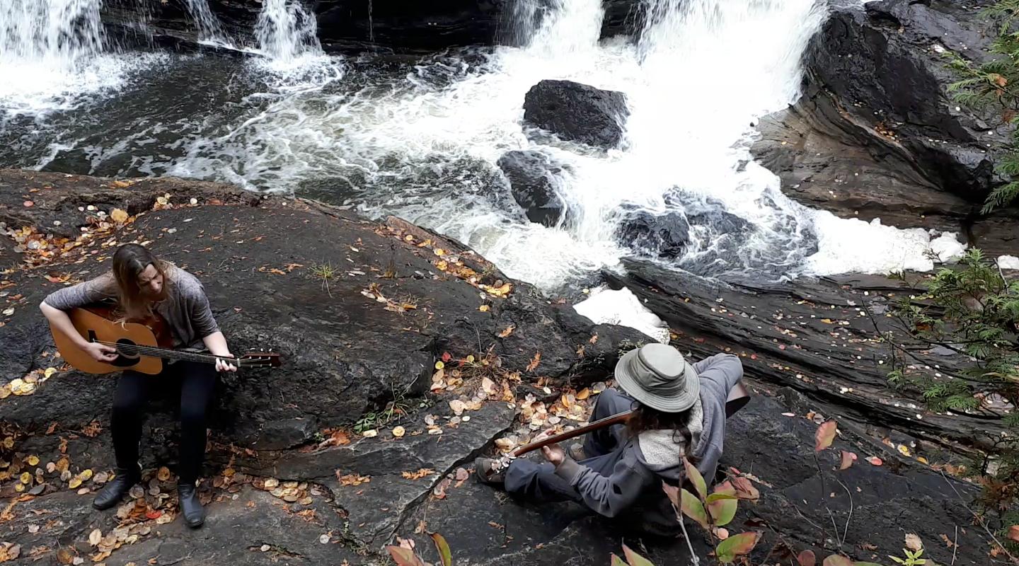 Overhead of Jenn and Matt playing beside small waterfall