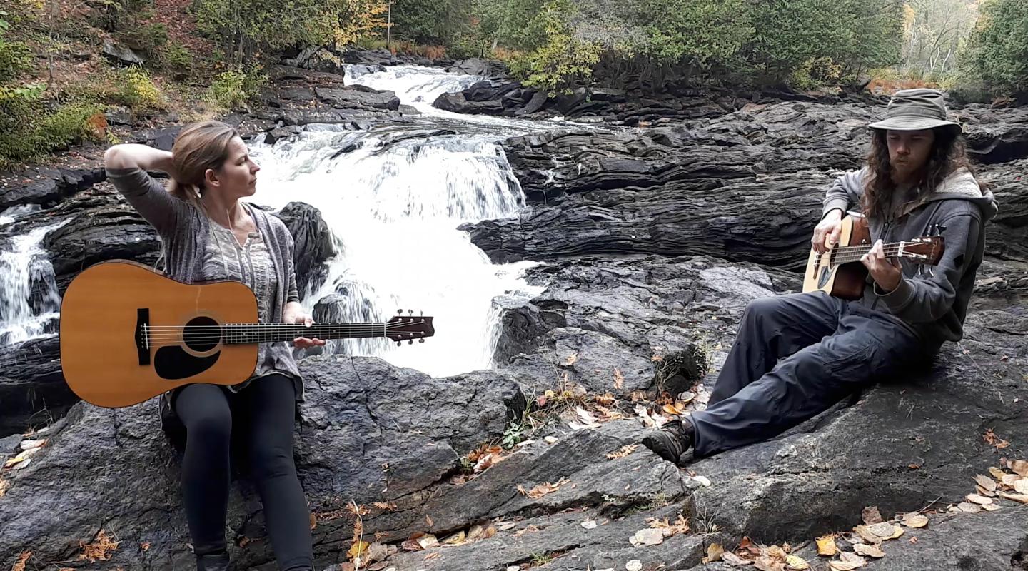 Jenn and Matt playing beside small waterfall